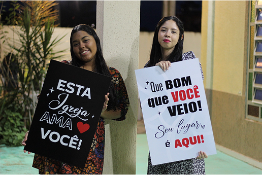 Membros da Primeira Igreja Batista do Lago Azul recebendo visitantes com um sorriso caloroso